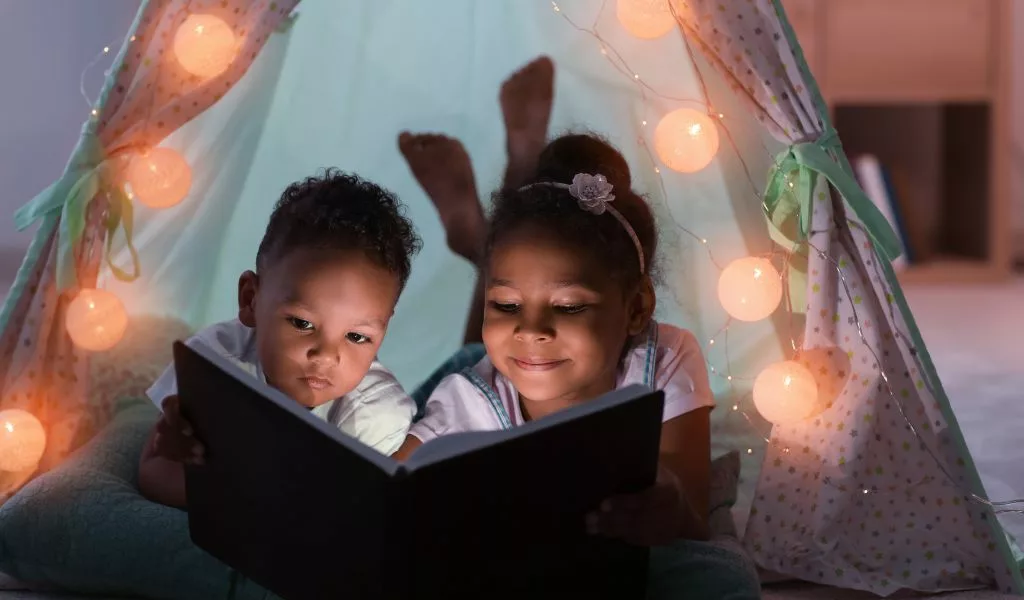 Enfants qui lisent un livre avant de dormir