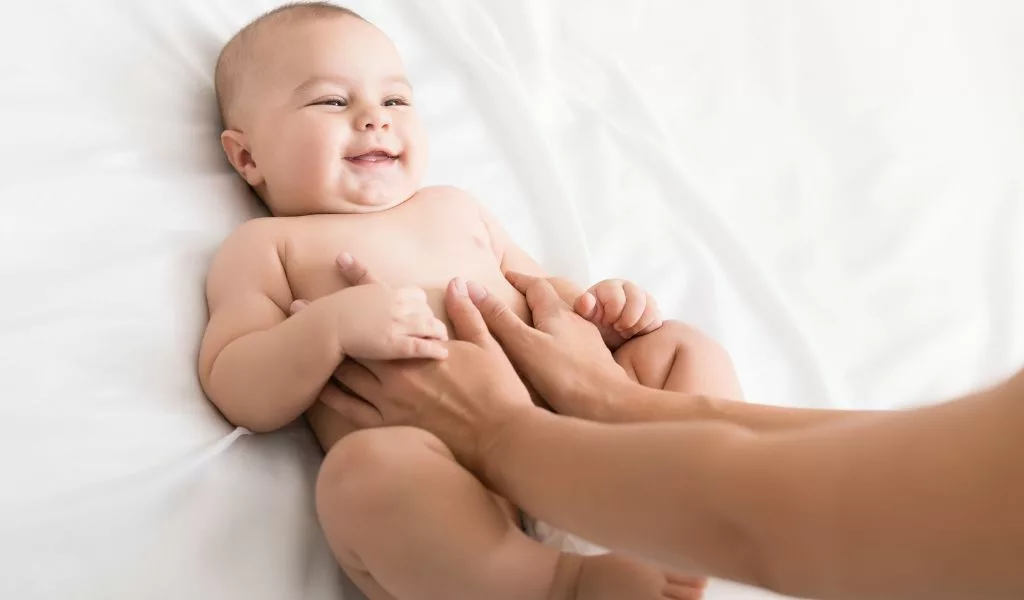 Massage doux du ventre d'un bébé pour soulager les coliques